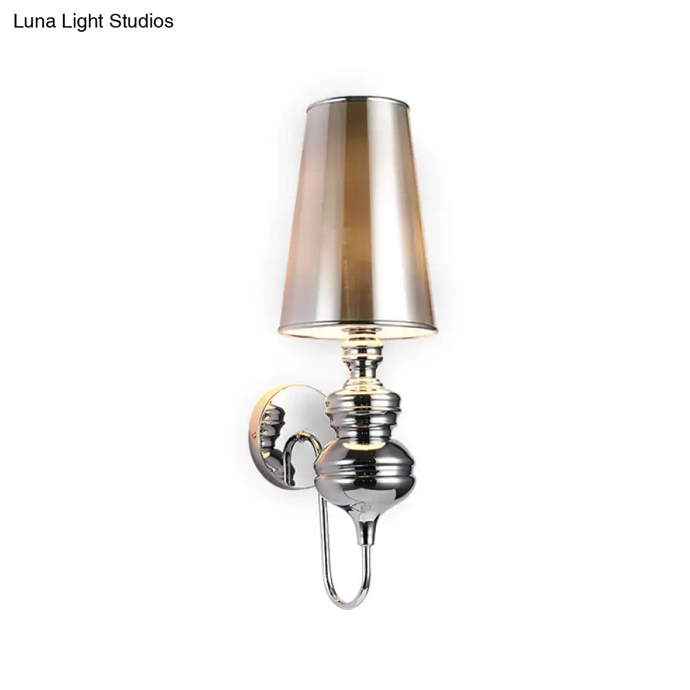 Contemporary matte black wall mount light with chrome finish and tapered smoked glass shade for bedroom use