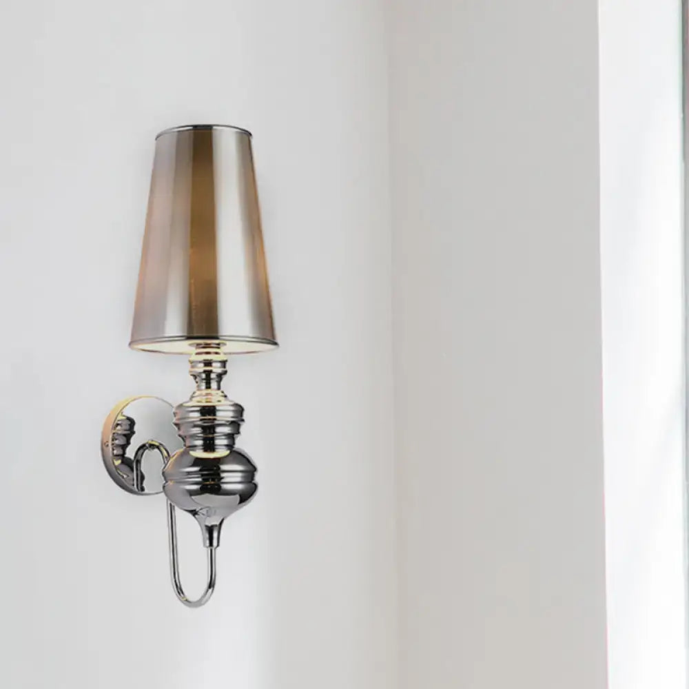 Chrome-finished wall mount light with tapered smoked glass shade for contemporary matte black bedroom sconce design