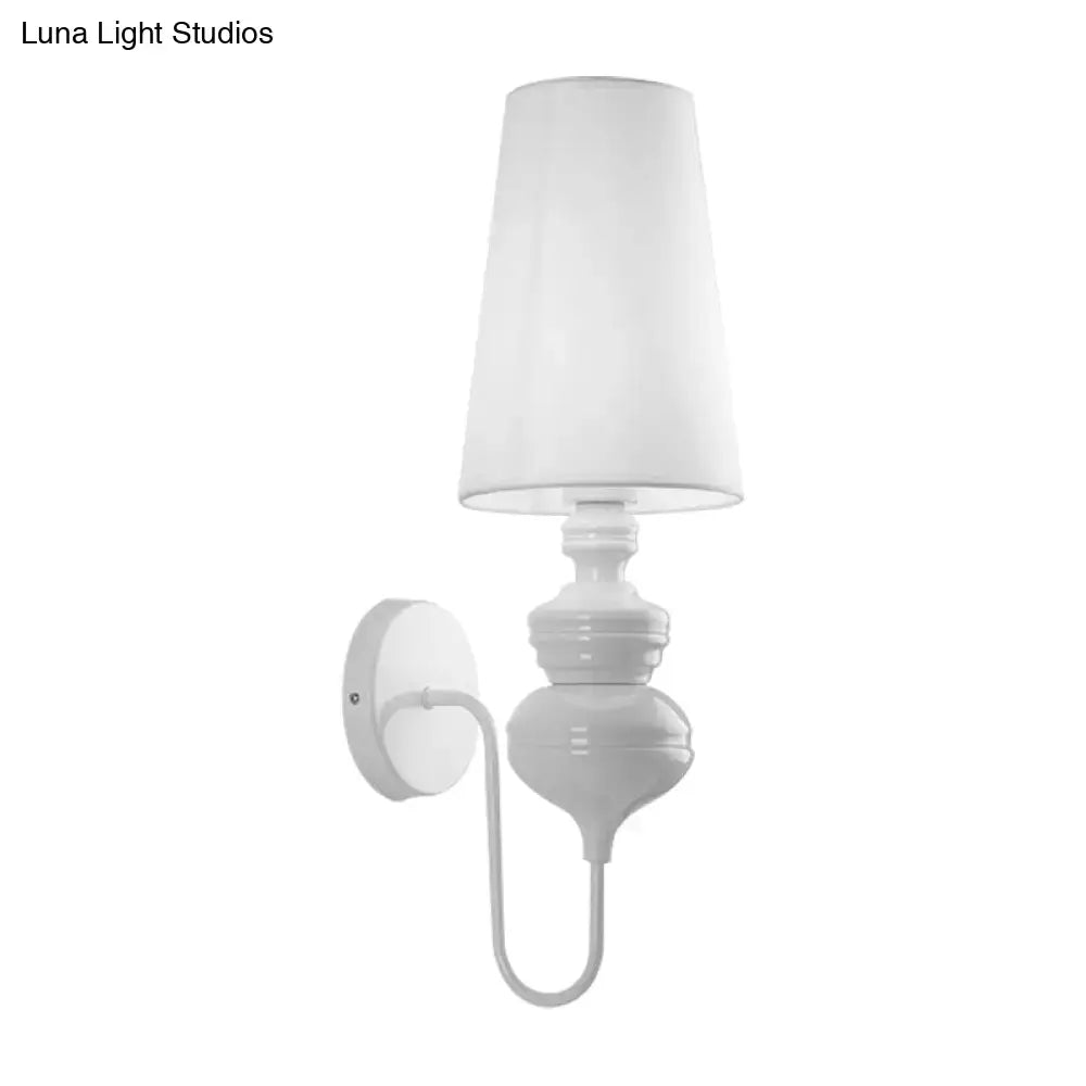 White ceramic wall mount light with tapered fabric shade and curved arm for contemporary bedroom lighting