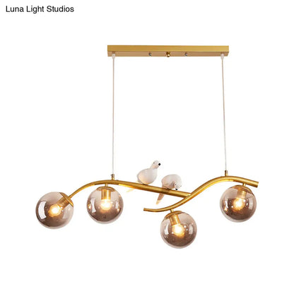 مصباح معلق عصري على شكل فرع معدني من DecorBites™ - 4 مصابيح باللونين الأسود والذهبي مع ديكور الطيور وغطاء زجاجي رمادي دخاني/كونياك