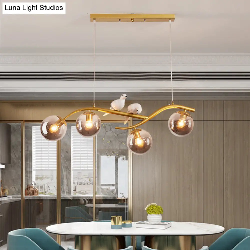 مصباح معلق عصري على شكل فرع معدني من DecorBites™ - 4 مصابيح باللونين الأسود والذهبي مع ديكور الطيور وغطاء زجاجي رمادي دخاني/كونياك