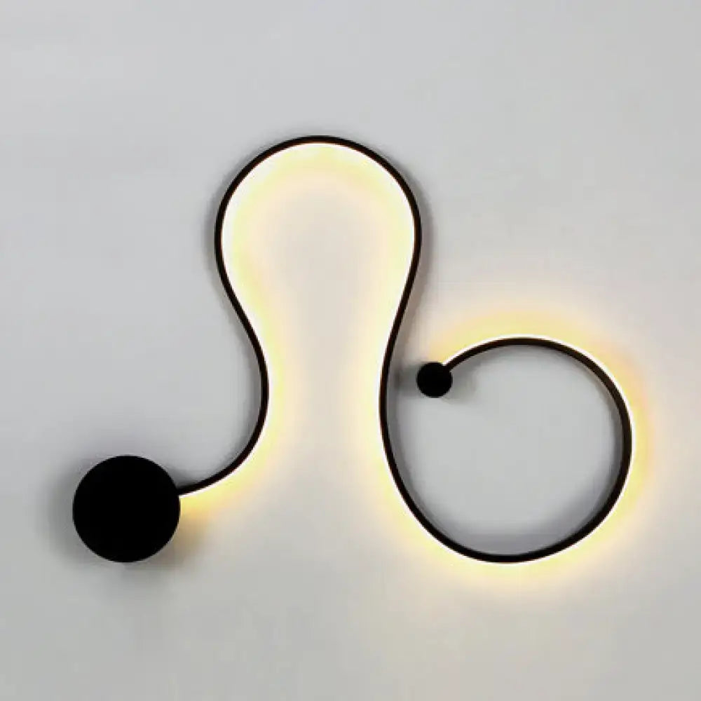 Contemporary twist black metal wall sconce with sleek abstract s-shaped design and white warm led bedroom lighting