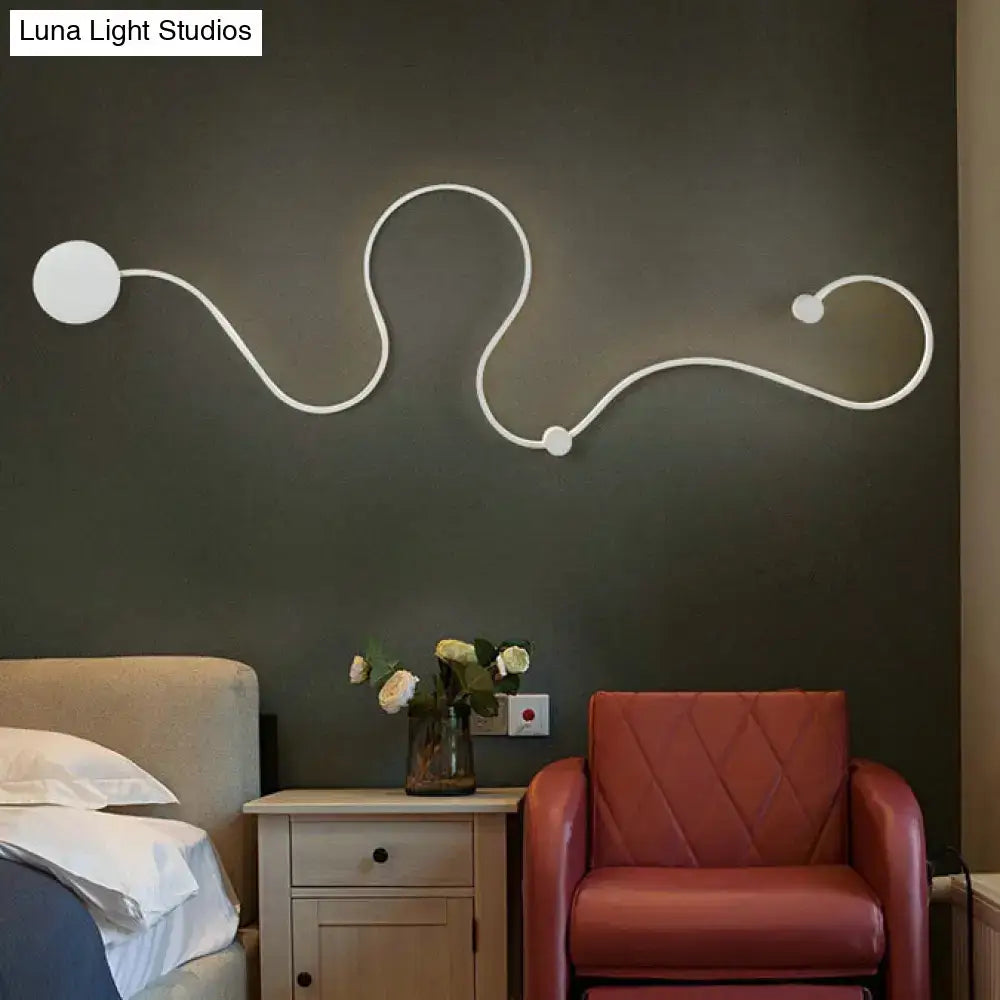 Contemporary twist wall sconce in white with three circular fixtures providing white warm bedroom light