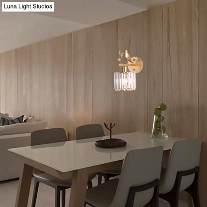 Aplique de pared contemporáneo DecorBites™ con cilindro de cristal K9, detalle de pájaro y acabado negro/dorado.