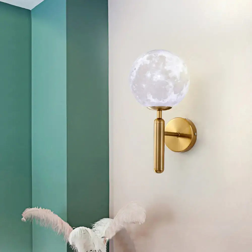 Contemporary white glass wall sconce featuring a gold-toned fixture with a translucent moon-patterned globe for bedroom use
