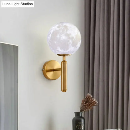 Contemporary white glass wall fixture featuring a gold-toned sconce with a translucent moon-patterned globe for bedrooms
