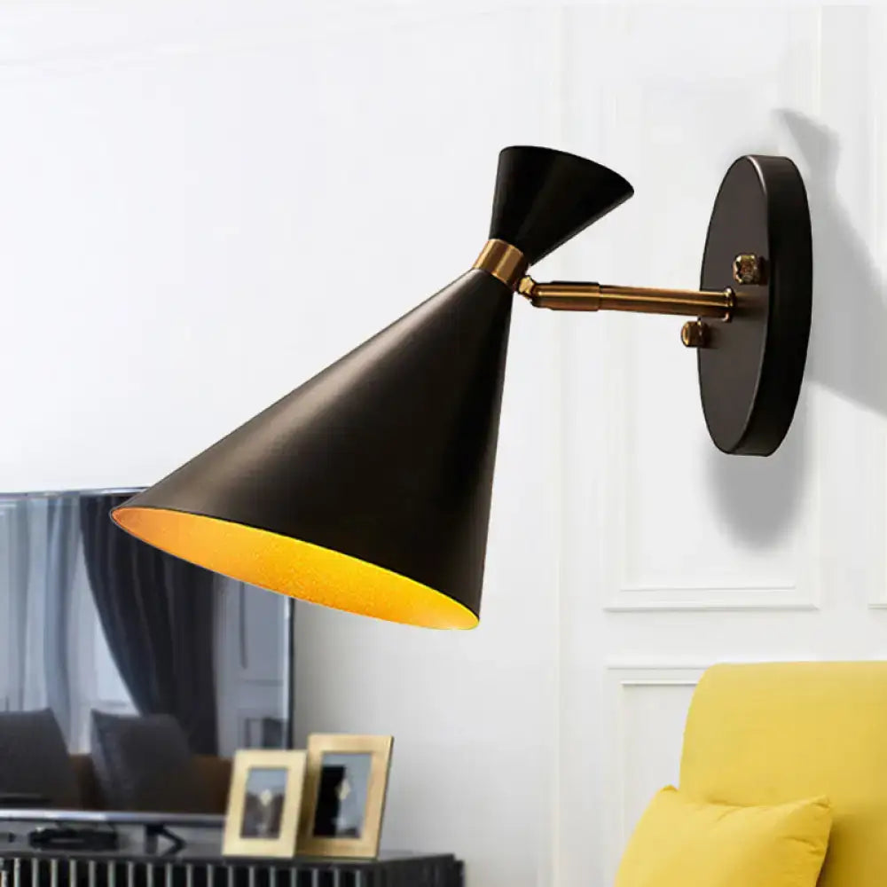 Black conical wall sconce with brass accent and warm yellow interior lining featuring an adjustable arm for bedroom use