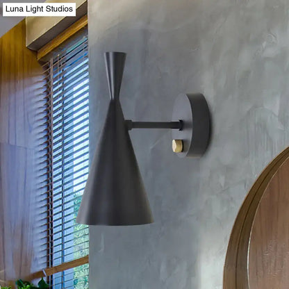 Black matte wall sconce with adjustable arm features sleek conical shade and brass accent ideal for bedroom lighting