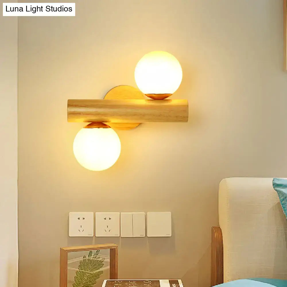 Contemporary white milk glass wall lamp with wooden base featuring two warm-toned spherical globes in a bathroom design
