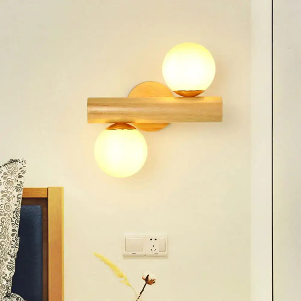 Contemporary white milk glass wall lamp with warm glowing bulbs mounted on wooden base and brass accents for bathroom