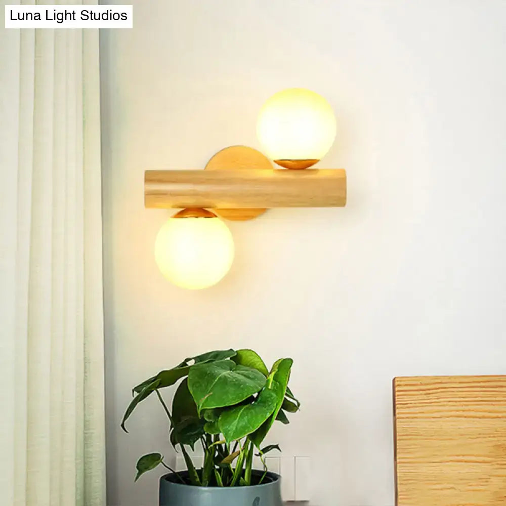 Contemporary white milk glass wall lamp with wooden base featuring two warm spherical bulbs for bathroom lighting