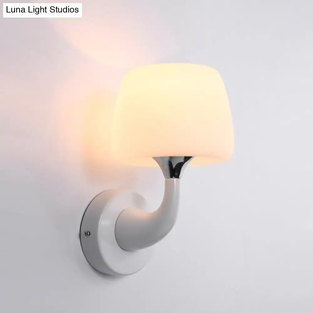 Contemporary white opal glass wall light with a sleek curved ceramic base and warm diffused glow light fixture