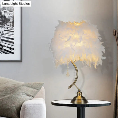 مصباح طاولة عصري باللونين الأبيض والوردي مع غطاء ريش وكريستال متدلٍ