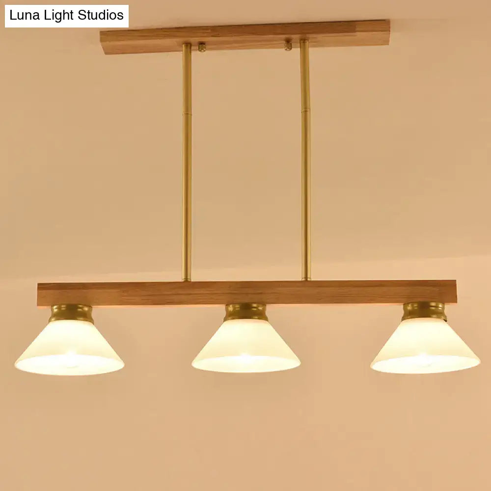 Contemporary wood linear island ceiling light with warm brass finish gold black accents and frosted glass shades