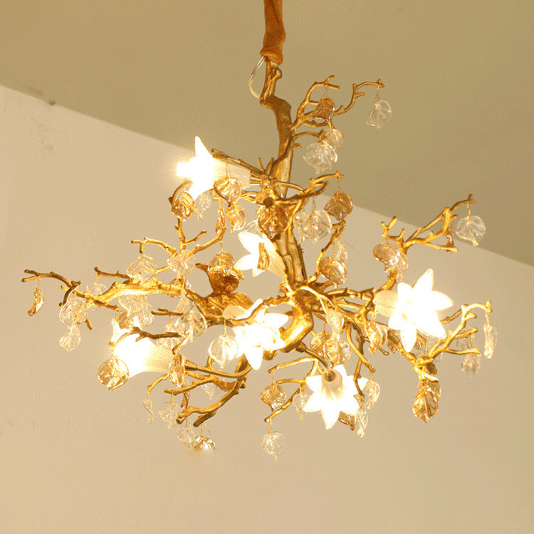 Gold tree branch chandelier with crystal accents and star-shaped lights.