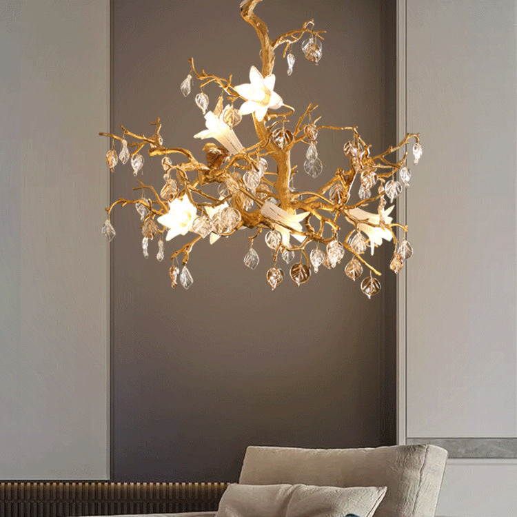 Gold floral chandelier with crystal accents and white flowers.