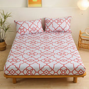 White fitted sheet set with coral red geometric floral pattern featuring interconnected green leaf flower shapes