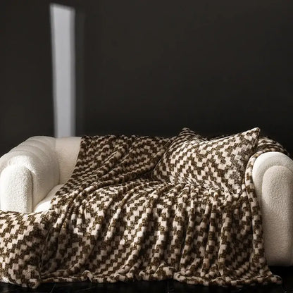 A cosy faux rabbit plush houndstooth throw blanket in cream and brown draped on a white sofa for living room decorbites cosy faux decor