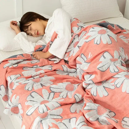 Coralb-colored cotton gauze boho throw with white daisies and gray outlines in soft plush material for bedroom decor