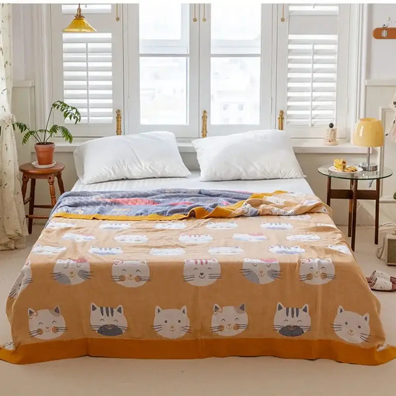 Cotton gauze boho throw blanket in orange with playful white gray and black cartoon cat faces for cozy decorbites decor