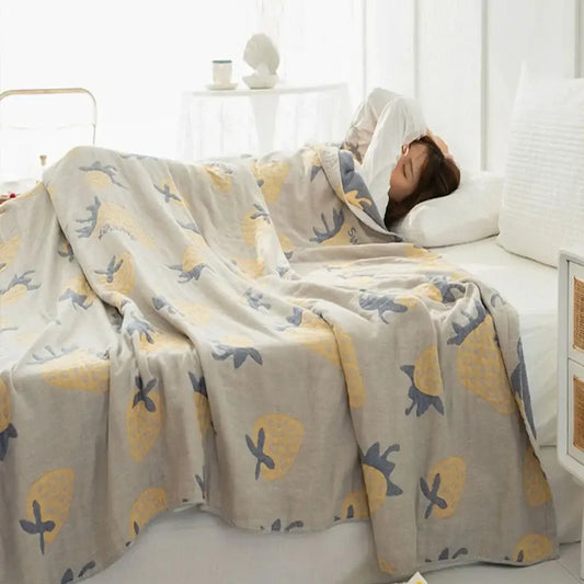A soft light gray decorbites cotton gauze boho throw with yellow pineapples and dark blue birds pattern