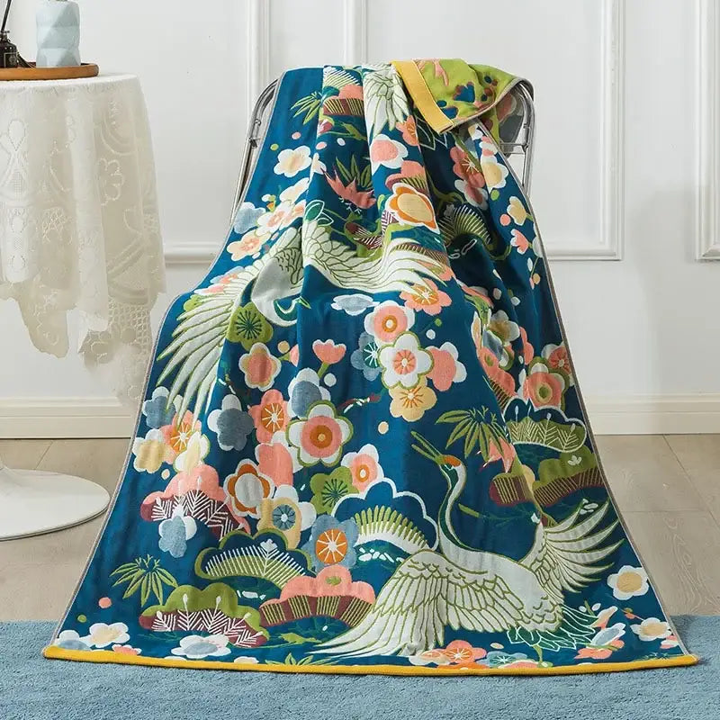 A vibrant blue decorbites cotton gauze peacock throw blanket with white crane floral patterns for bath towel or bedroom use