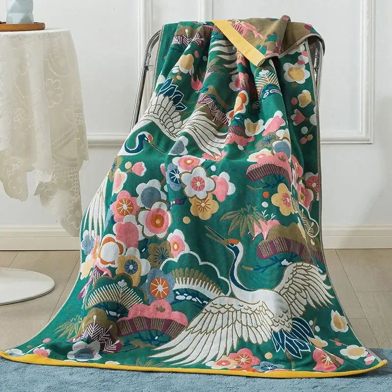 A plush green cotton gauze peacock throw blanket with white crane floral patterns and multicolor accents for bath towel decorbites
