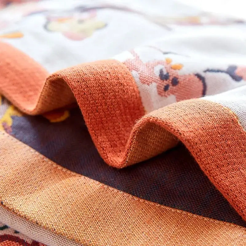 A soft orange linen cotton gauze peacock bath towel with subtle woven pattern and floral embroidery by decorbites