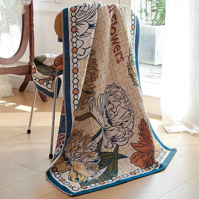 A cream-colored decorbites cotton gauze peacock bath towel with floral pattern and teal border for bedroom throw use