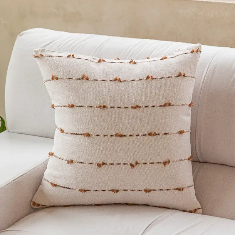 Cream-colored decorbites cotton stripe jacquard throw pillow with brown tassels and dark stitching for living room decor