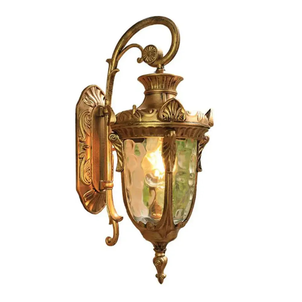 Antique brass-finished outdoor wall lantern with ornate scrollwork and textured green glass for outdoor wall use