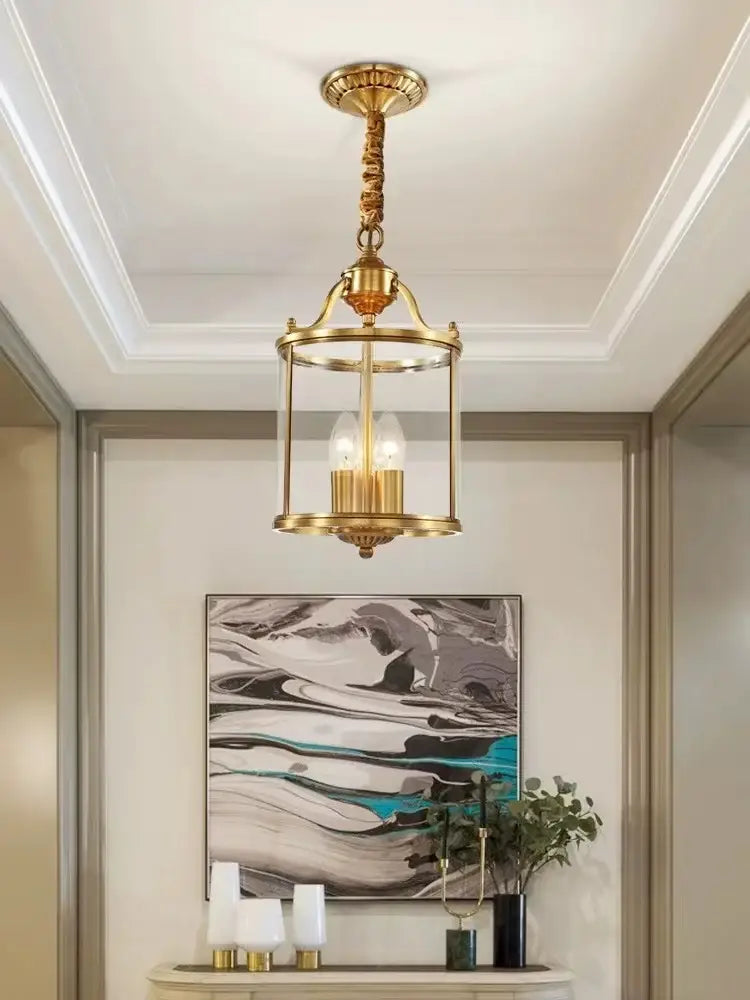 Brass pendant lights with cylindrical glass enclosure and three exposed bulbs in decorbites bronze glass chandelier style
