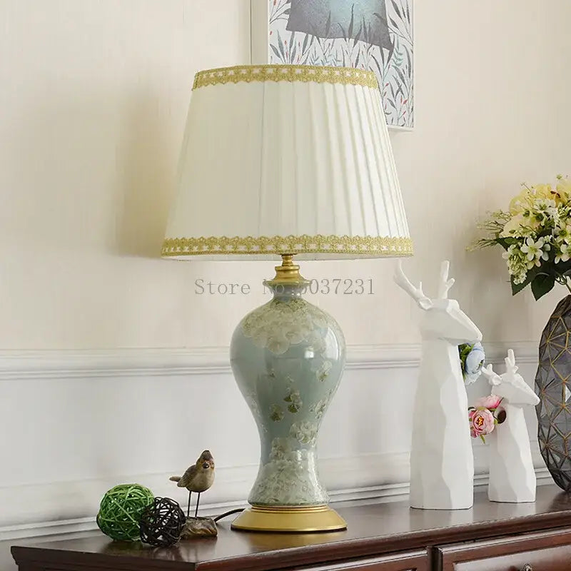 A delicate light green celadon country ceramic table lamp with gold accents and pleated cream shade for bedroom decor