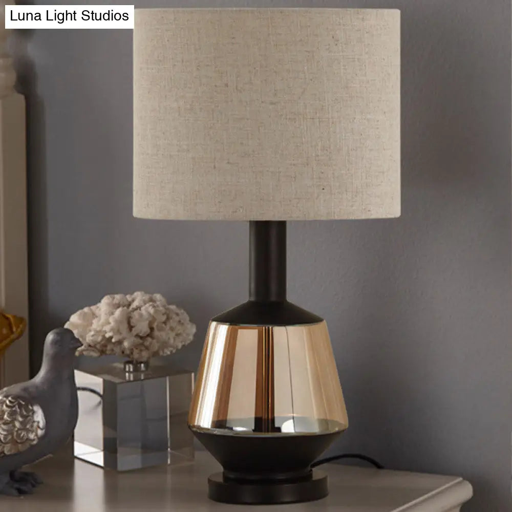 مصباح طاولة بجانب السرير على شكل أسطوانة ريفية مع قاعدة زجاجية بلون العنبر - غطاء قماش أبيض/بيج