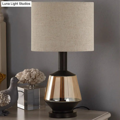 مصباح طاولة بجانب السرير على شكل أسطوانة ريفية مع قاعدة زجاجية بلون العنبر - غطاء قماش أبيض/بيج