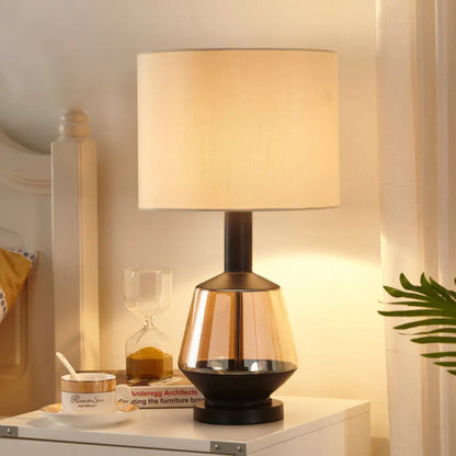 مصباح طاولة بجانب السرير على شكل أسطوانة ريفية مع قاعدة زجاجية بلون العنبر - غطاء قماش أبيض/بيج