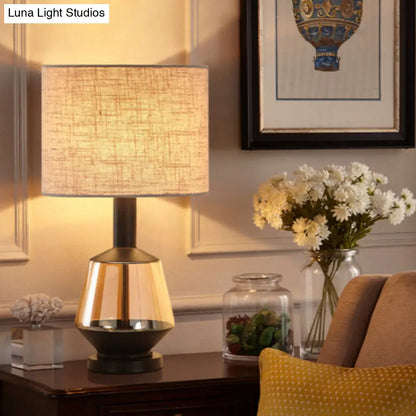 مصباح طاولة بجانب السرير على شكل أسطوانة ريفية مع قاعدة زجاجية بلون العنبر - غطاء قماش أبيض/بيج