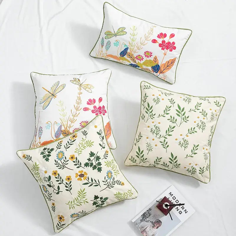 Cream-colored floral embroidered cushion cover with intricate dragonfly designs in vibrant pink green yellow and blue hues