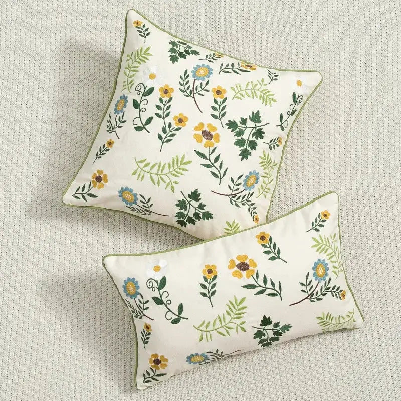 Cream-colored cushion cover with embroidered yellow blue and green floral patterns for living room use