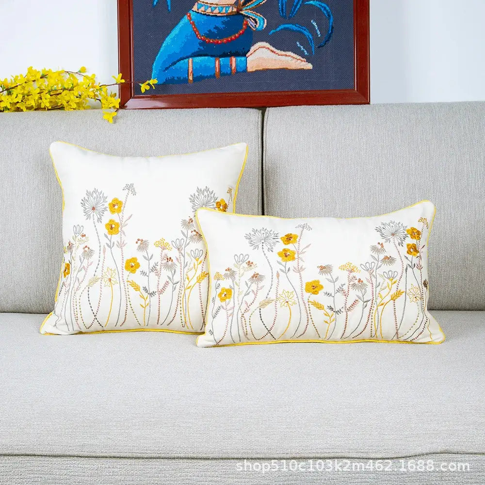 White rectangular cushion cover with floral embroidered yellow and gray patterns and a thin yellow border for living room decor