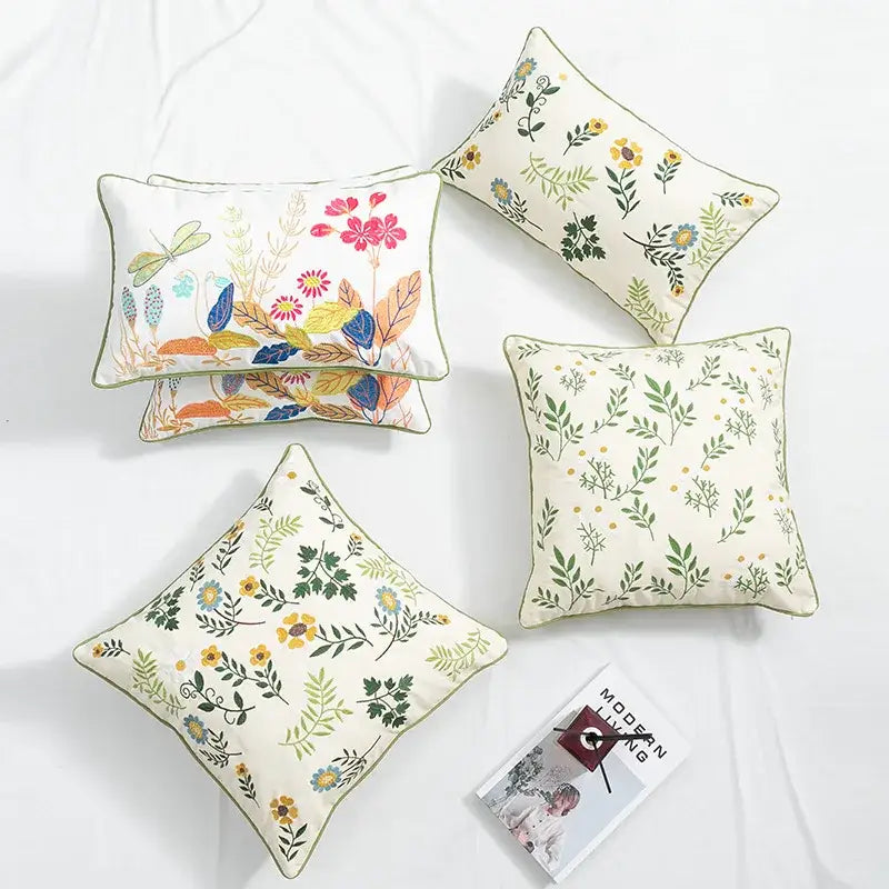 Set of four cream floral embroidered cushion covers with green piping and colorful botanical patterns for living room