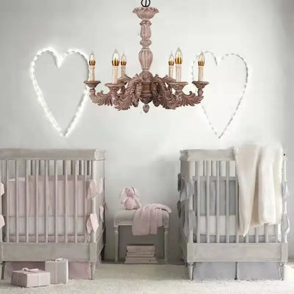 A delicate rose-gold country french solid wood chandelier with six candle-style bulbs above matching gray cribs
