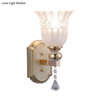 Elegant gold finish glass floral wall sconce with frosted glass floral shade and crystal teardrop pendant for bedroom lighting