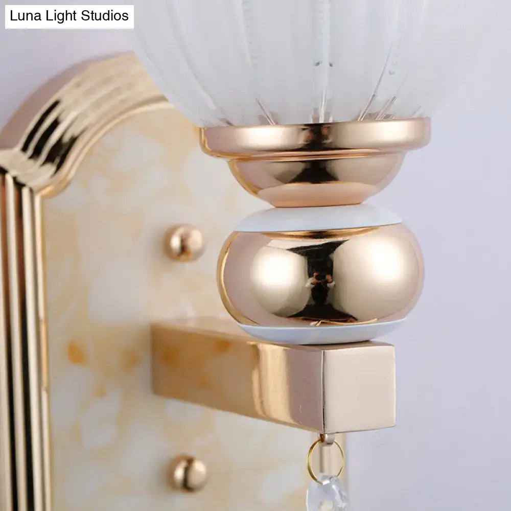 Gold finish country gold frosted glass floral wall sconce with ribbed glass shade and polished metallic accents for bedroom lighting