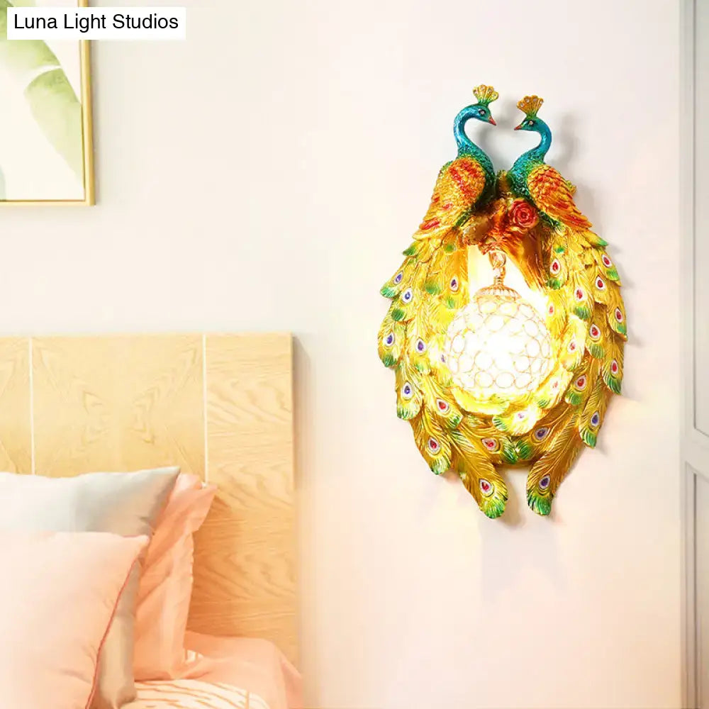 Country gold peacock wall sconce with teal and gold feathers, glowing orb, crafted from painted resin for bedroom crystal light