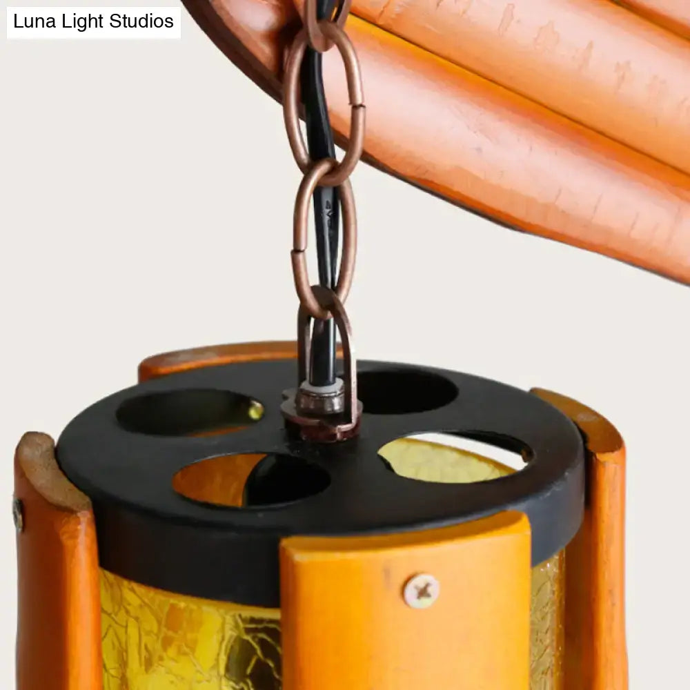 A warm amber crackle glass hanging light with black metal top and branch accent by decorbites for restaurants
