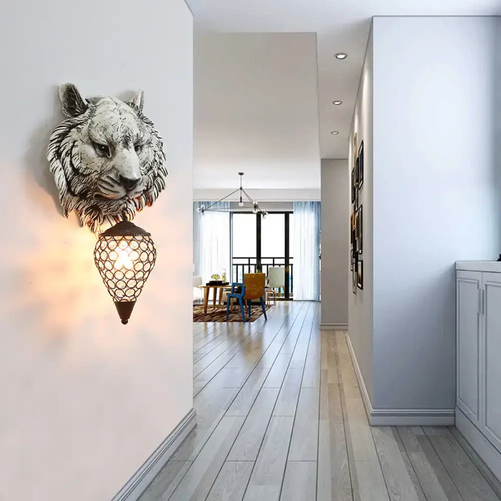 Country tiger head wall lamp with grayish-white sculpted tiger head and ornate black lantern featuring a clear crystal shade