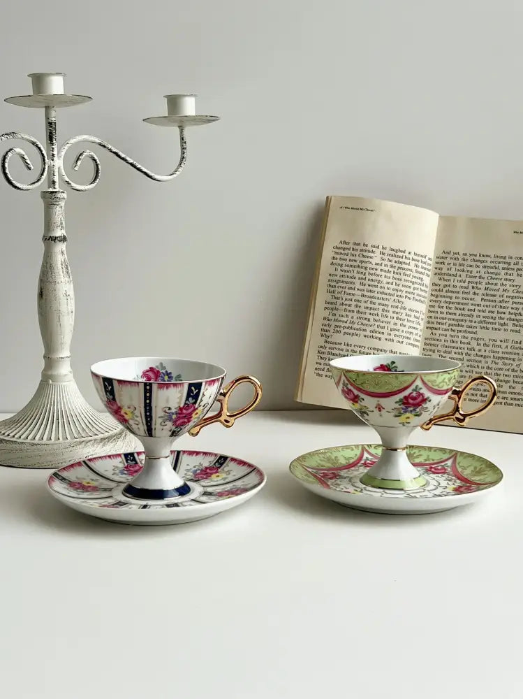 Two ornate court style porcelain cup set with gold handles and floral patterns on matching saucers for dining room decorbites court style
