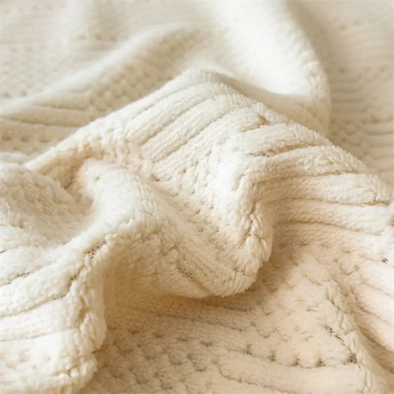 Cream-colored plush knit throw blanket with textured cable-knit pattern in decorbites cozy carved velvet bedroom throw