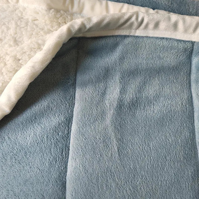 Cozy coral fleece blue and white quilted blanket featuring soft light blue fleece and plush white sherpa lining